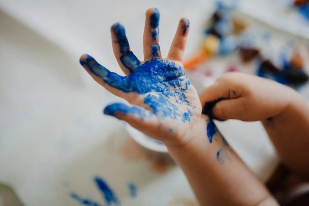 Hand of a child with blue water color on it.